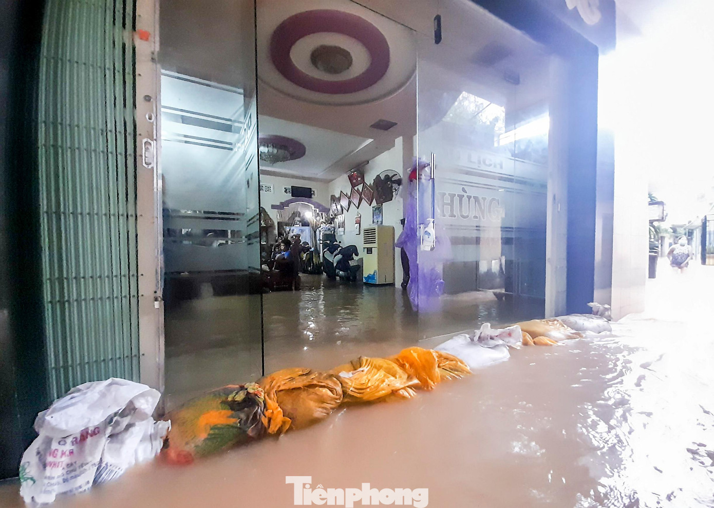 Người dân dùng bao cát để ngăn nước trào vào nhà. Ảnh: Trương Định Người dân dùng bao cát để ngăn nước trào vào nhà. Ảnh: Trương Định