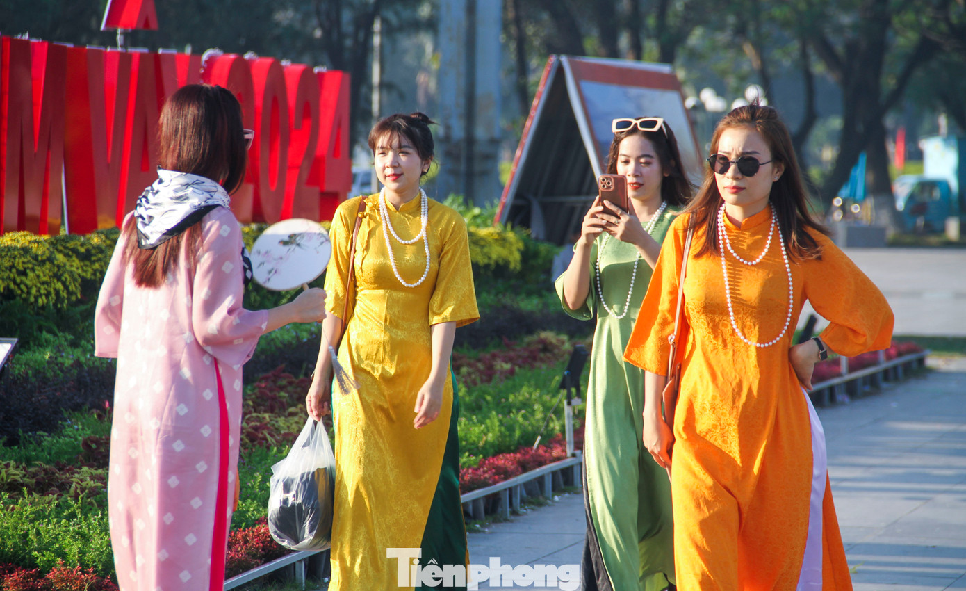 Từ sáng sớm, nhiều người dân và du khách đã diện áo dài xuống phố đón Tết, vui Xuân sớm. Ảnh: Trương Định