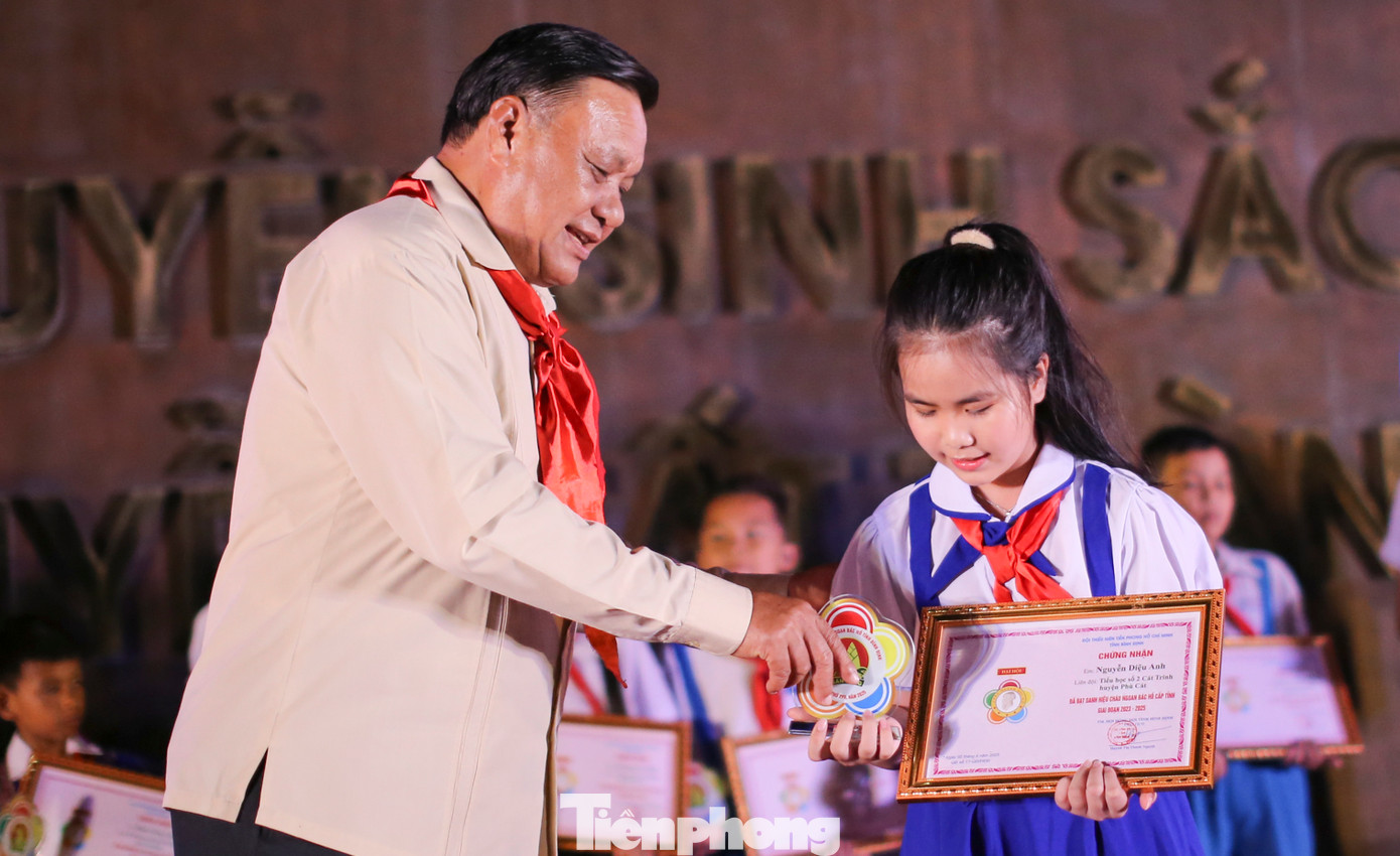 Ông Lê Kim Toàn - Phó Bí thư Thường trực Tỉnh ủy, Trưởng đoàn Đoàn ĐBQH tỉnh Bình Định trao danh hiệu cháu ngoan Bác Hồ cho các em thiếu nhi. Ảnh: Trương Định