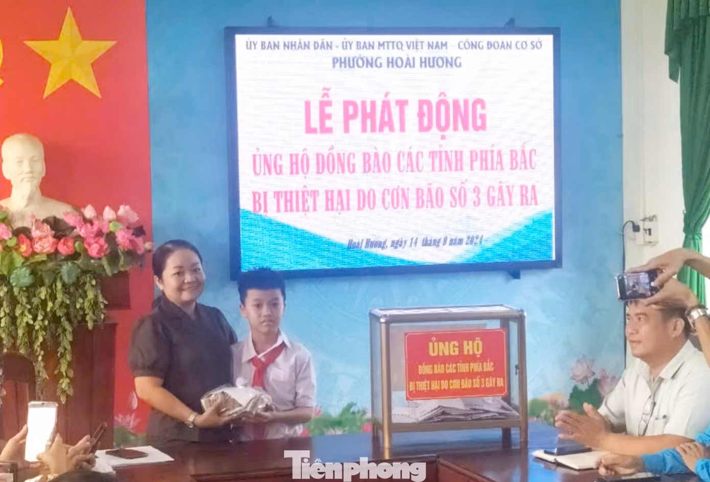 Sáng nay (14/9), em Trịnh Hồng Vinh cùng mẹ mang số tiền gom góp được tới trụ sở phường Hoài Hương để ủng hộ. Ảnh: Gia đình cung cấp