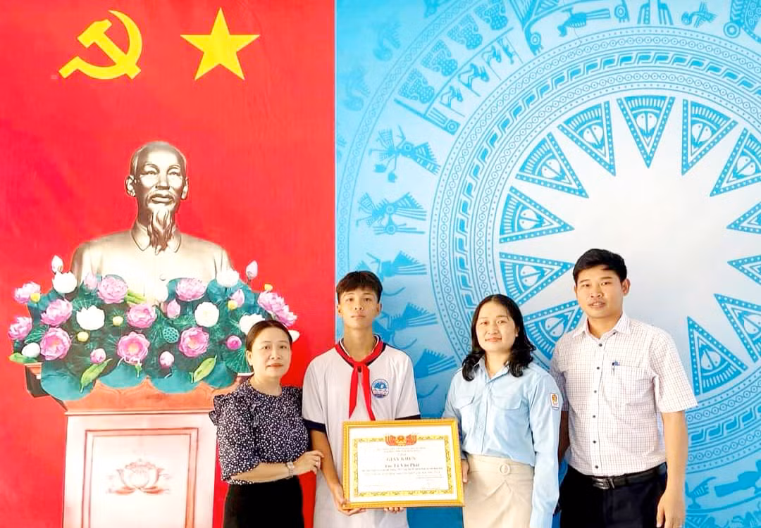Chị Huỳnh Thị Thanh Nguyệt - Phó Bí thư Tỉnh Đoàn Bình Định (thứ 2 bên phải qua) tặng giấy khen cho em Phát.