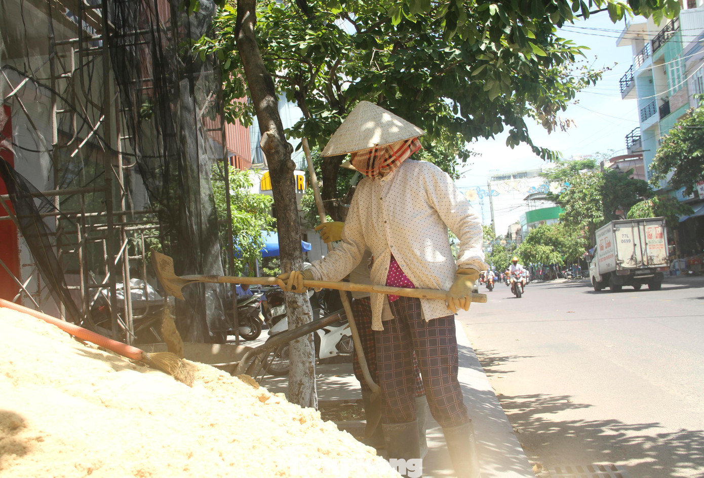 Trước sức nóng từ mặt đường nhựa, động cơ từ các phương tiện lưu thông nhiều người cố nép vào bóng râm để vừa "trốn" nắng, vừa tranh thủ làm việc.