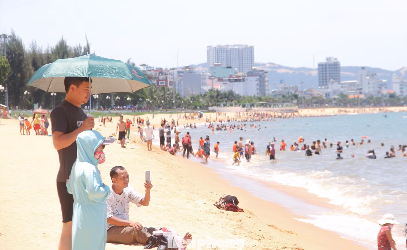 Theo ghi nhận, 12h trưa, hàng ngàn người dân từ người già, thanh thiếu niên cho đến trẻ em kéo nhau xuống biển tắm. Ảnh: Trương Định