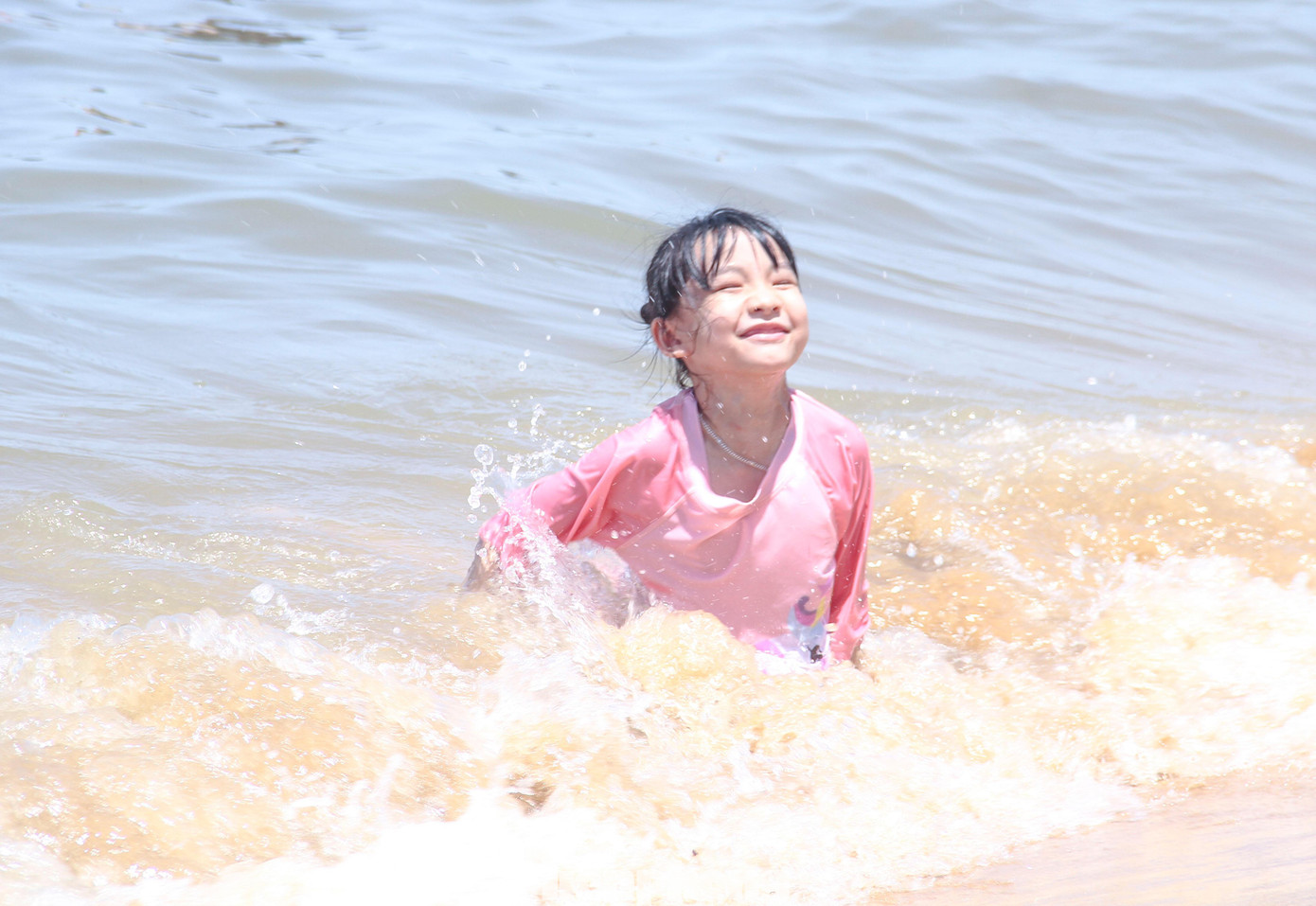 Các em nhỏ rất thích thú được bố mẹ đưa đi tắm biển. Ảnh: Trương Định