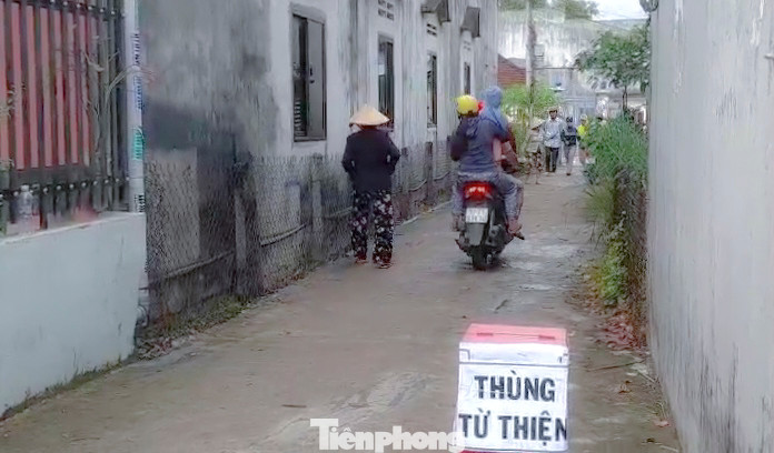 Thùng quyên góp từ thiện đặt trước hẻm dẫn vào gia đình ông C. Ảnh: Trương Định