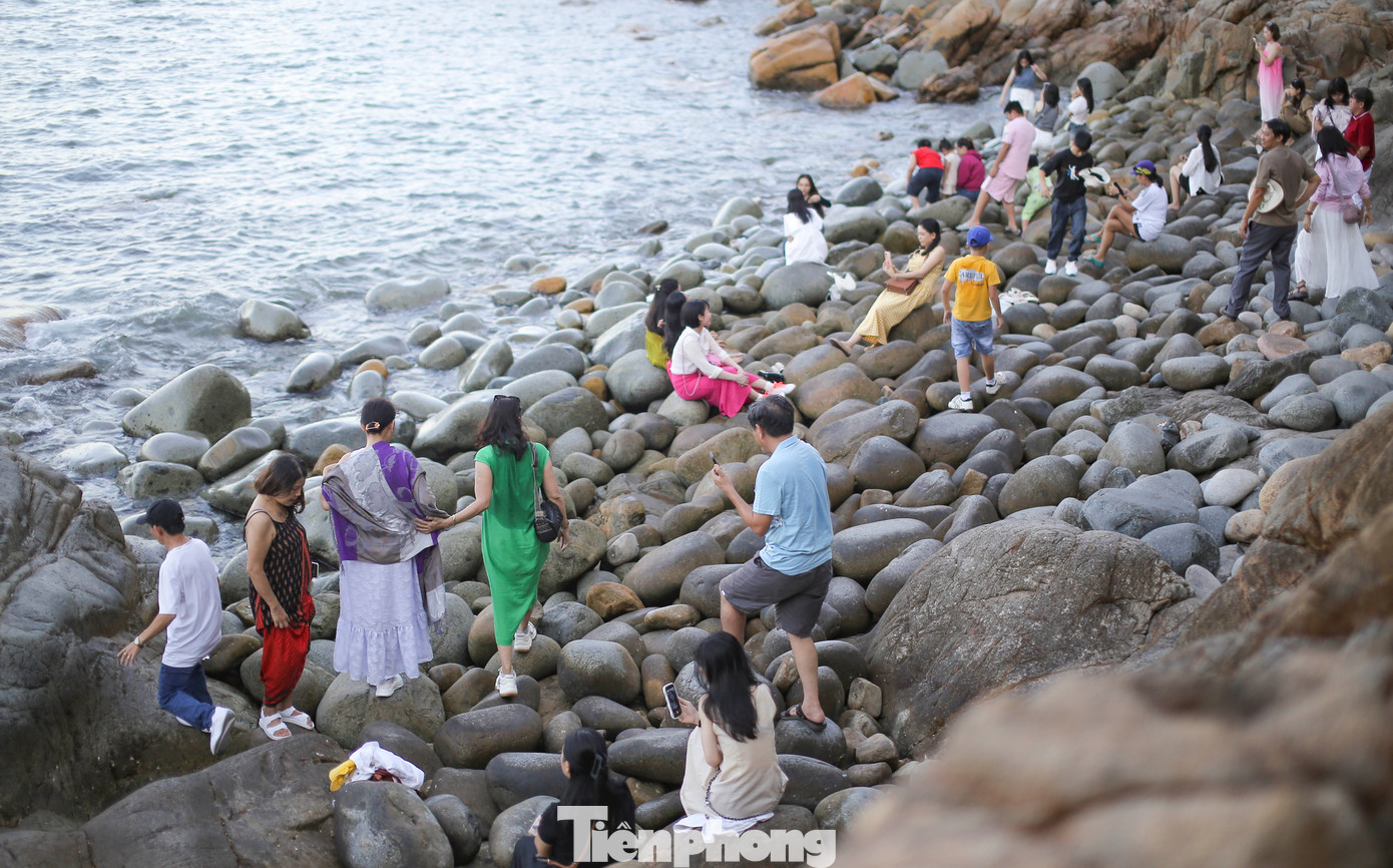Khách du lịch tham quan, khám phá bãi đá trứng. Ảnh: Trương Định.