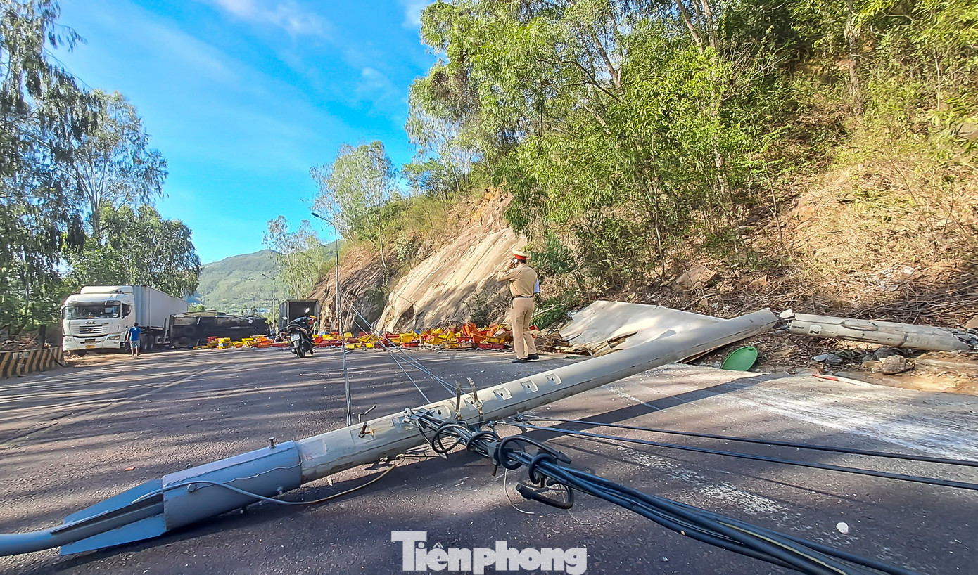 Theo camera hành trình từ một phương tiện khác ghi lại, khi đang xuống dốc thì chiếc xe tải chở cá vượt lên. Lúc này, xe chao đảo rồi lật nghiêng sau đó bất ngờ mất lái đâm vào vách núi rồi lật ngang xuống đường. Trong ảnh một trụ điện bị xe chở cá tông gãy. (Ảnh: Trương Định)