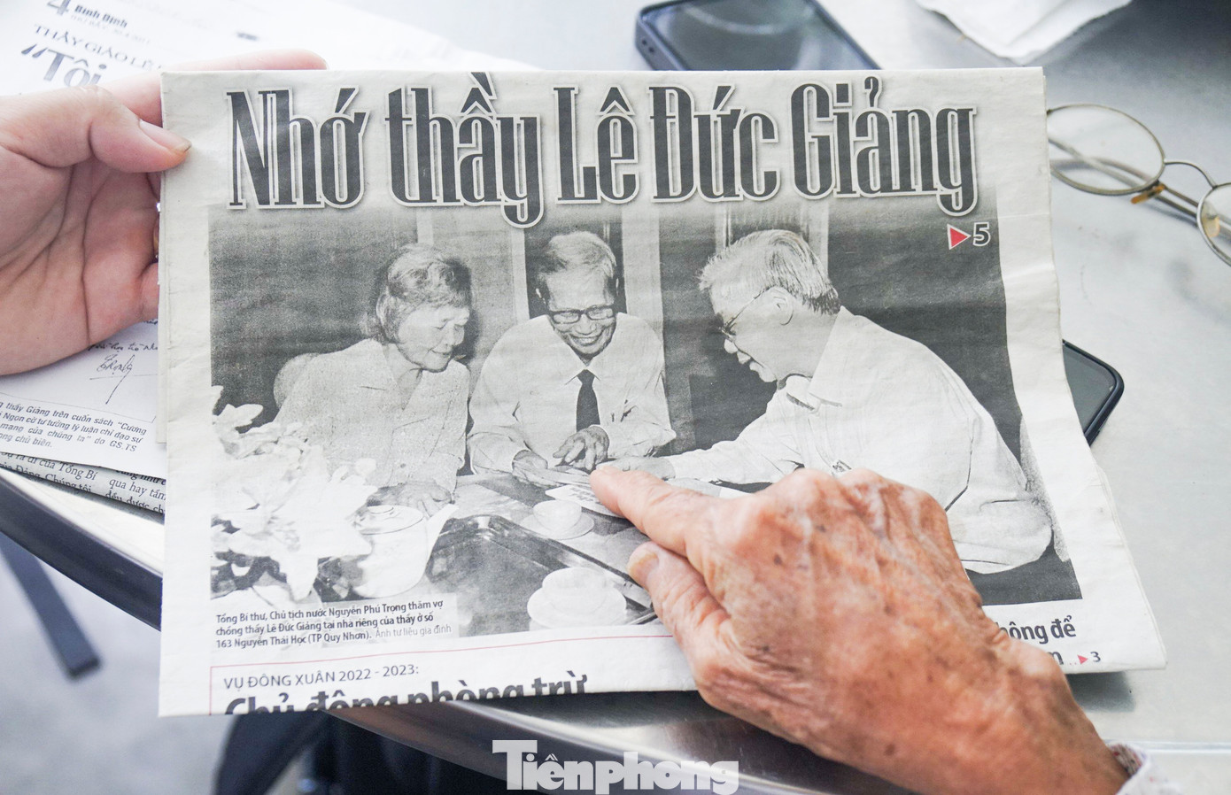 Cụ Cấu cho PV xem lại bức ảnh thời điểm Tổng Bí thư, Chủ tịch nước Nguyễn Phú Trọng thăm vợ chồng mình tại nhà riêng ở đường Nguyễn Thái Học (TP. Quy Nhơn) được đăng báo. Ảnh: Trương Định