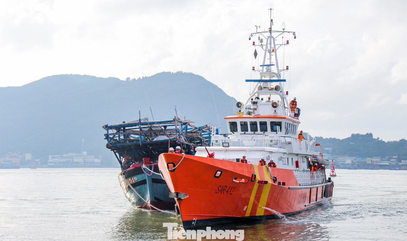 Tàu SAR 412 hỗ trợ, lai dắt tàu cá QNg 90251-TS vào bờ. Ảnh: Trương Định. Tàu SAR 412 hỗ trợ, lai dắt tàu cá QNg 90251-TS vào bờ. Ảnh: Trương Định.