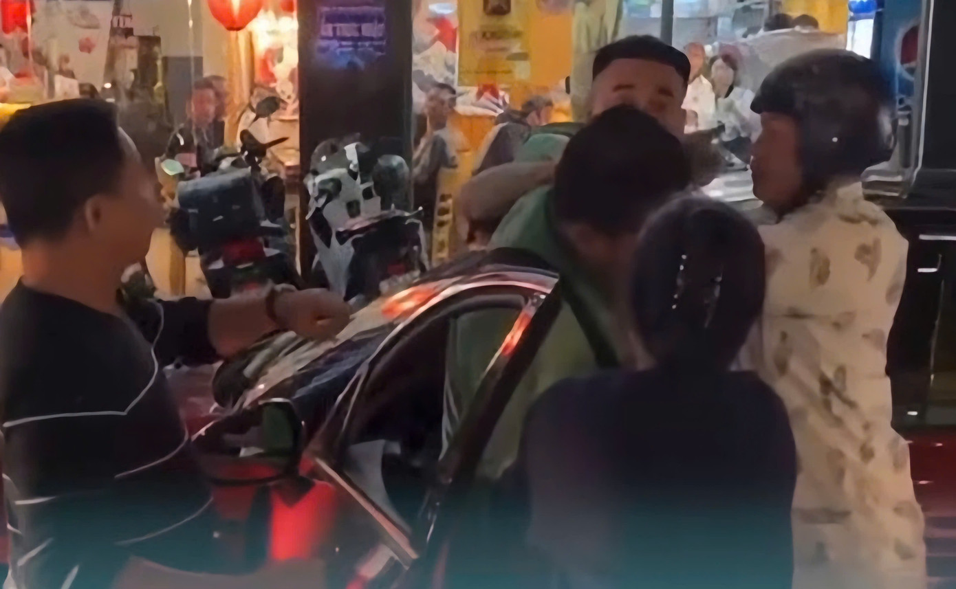Người dân can ngăn tài xế ô tô khi ra tay đánh tài xế chạy grap. Ảnh cắt từ clip