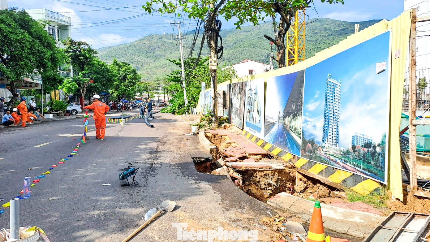 Dọc tuyến đường, lực lượng chức năng đang giăng dây để bảo vệ hiện trường, không cho người dân lại gần để đảm bảo an toàn. Một số đơn vị đang tiến hành khắc phục đường ống nước qua khu vực bị sụt lún. Ảnh: Trương Định