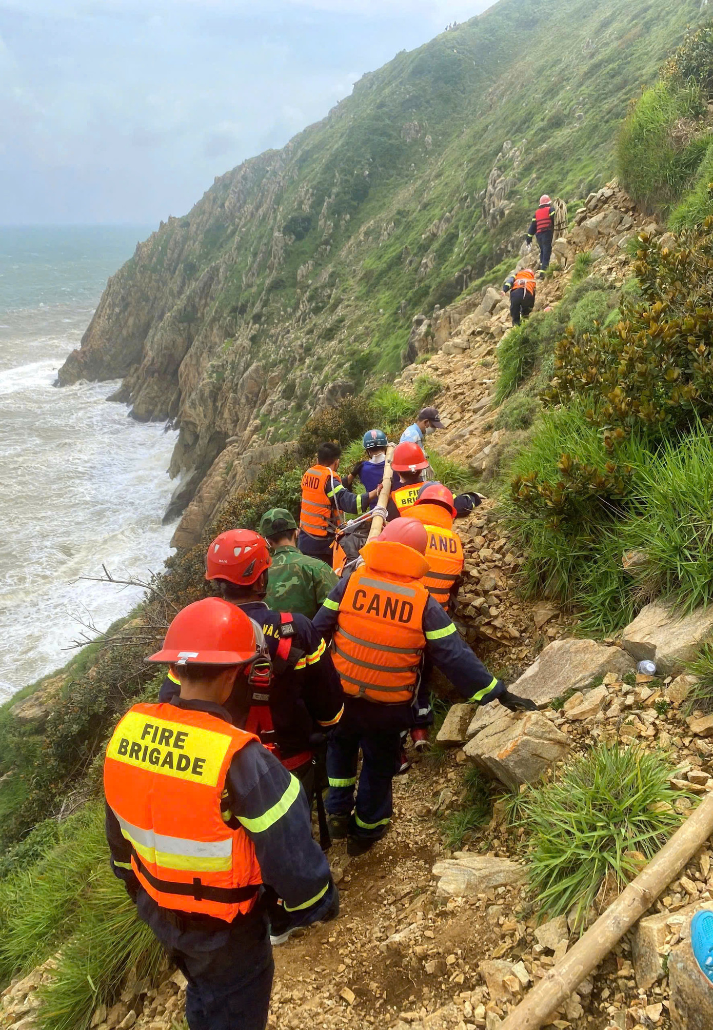 Khu vực người đàn ông bị nạn có vách núi dựng đứng cao hàng trăm mét. Trong ảnh - lực lượng cứu nạn, cứu hộ đưa thi thể nạn nhân lên bờ. Khu vực người đàn ông bị nạn có vách núi dựng đứng cao hàng trăm mét. Trong ảnh - lực lượng cứu nạn, cứu hộ đưa thi thể nạn nhân lên bờ.
