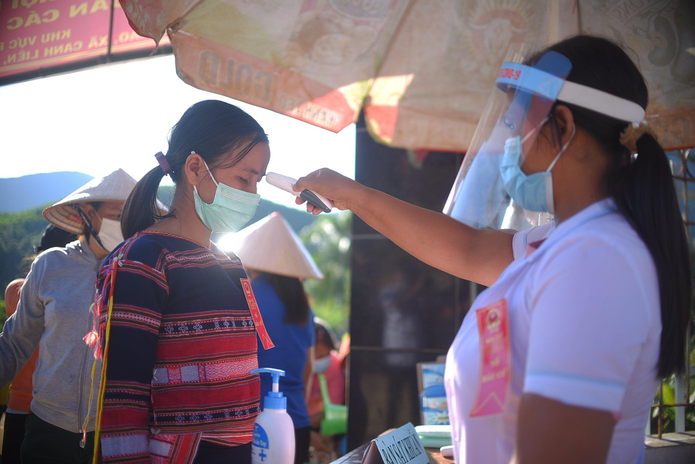 Nhân viên y tế kiểm tra thân nhiệt các cử tri.