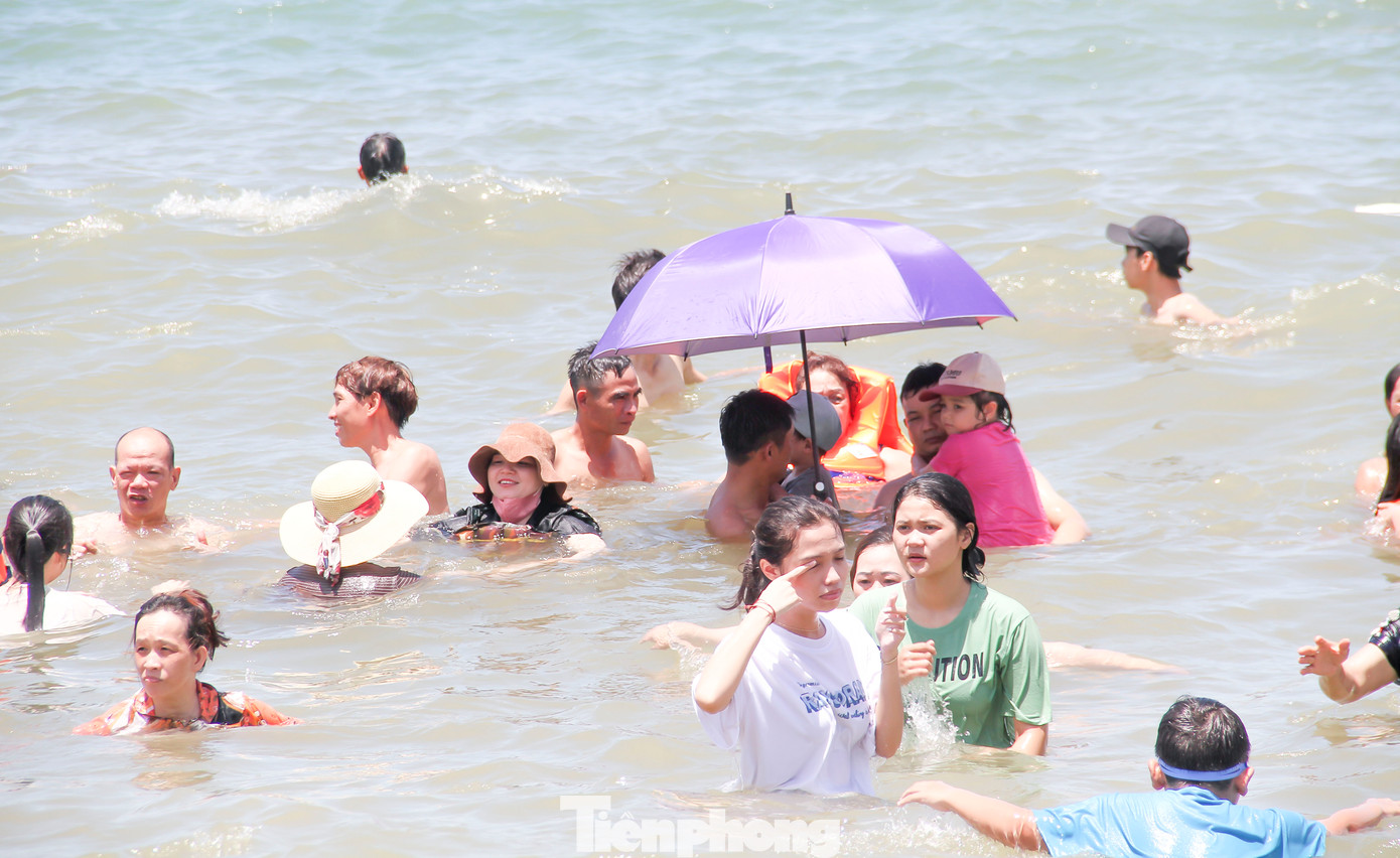 Người dân, du khách đội mũ, che ô tắm biển xả xui ngày Tết Đoan Ngọ. Ảnh: Trương Định Người dân, du khách đội mũ, che ô tắm biển xả xui ngày Tết Đoan Ngọ. Ảnh: Trương Định