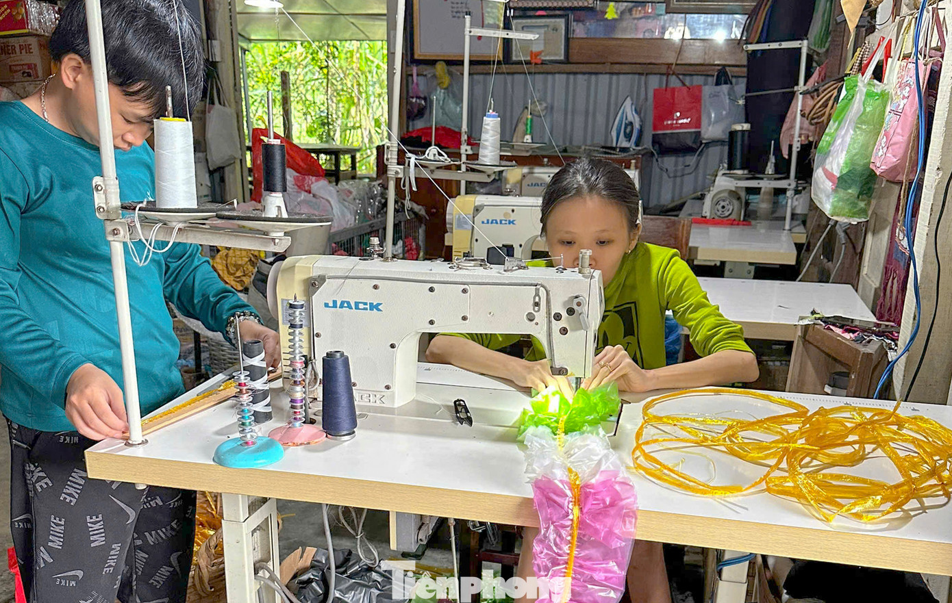 Các bạn khuyết tật kết những bì ni lông lại với nhau để trang trí cây thông Noel.