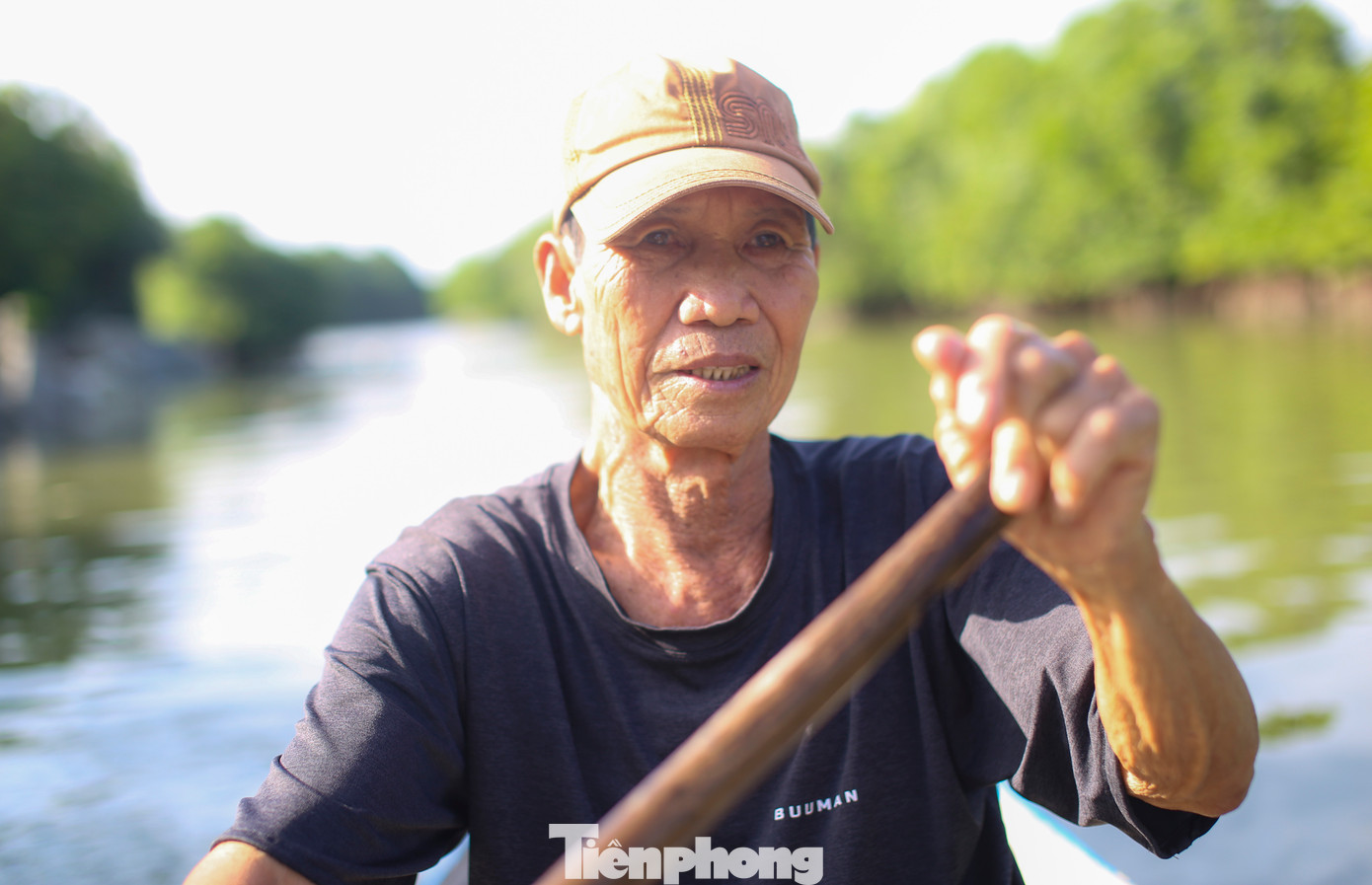 Ông Trần Hữu Khánh chèo sõng ra thăm cánh rừng ngập mặn. Ảnh: Trương Định