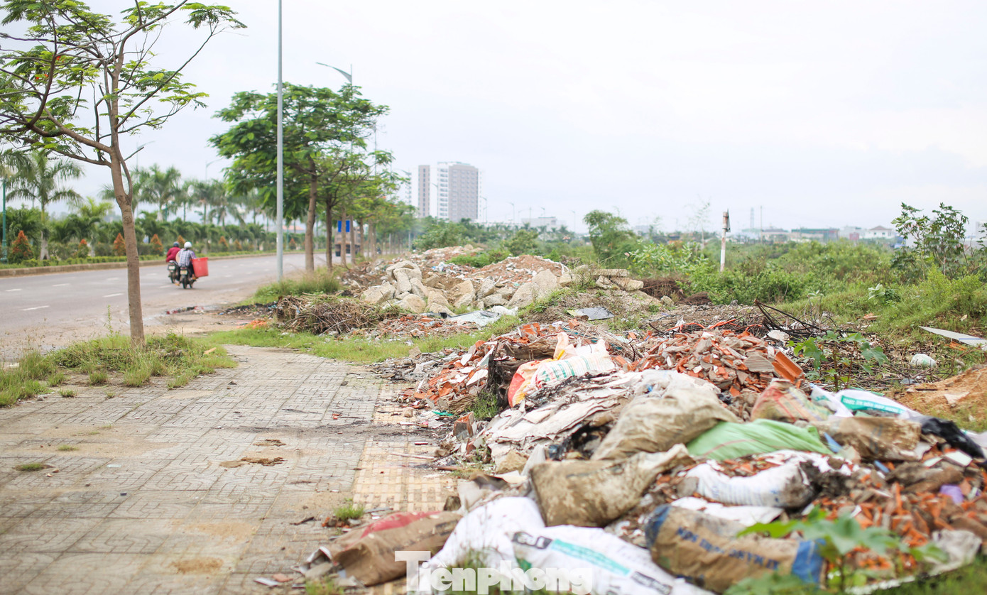 Sáng 4/12, ghi nhận của PV Tiền Phong, vỉa hè 2 bên đường dọc tuyến từ cầu Long Vân 2 chạy về hướng TP. Quy Nhơn, những "núi" xà bần đổ ngổn ngang, xen lẫn vào đó là những đống rác lớp cũ, mới chồng lên nhau, một số đã được đốt bỏ. Ảnh: Trương Định