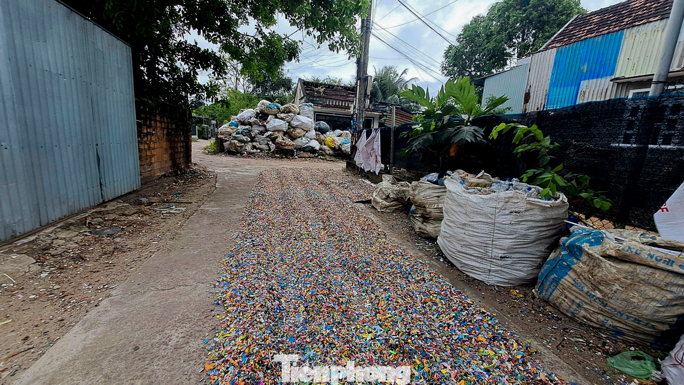 Nhựa sau khi được xay nhỏ được phơi ngay ra ngoài đường. Ảnh: Trương Định.