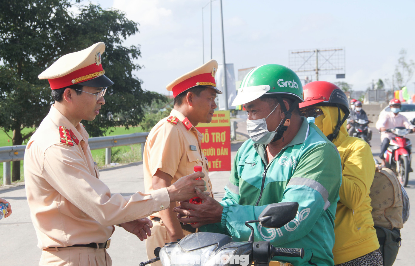 Lực lượng CSGT Công an tỉnh Bình Định thăm hỏi, tặng nước uống cho người dân đi đường. (Ảnh: Trương Định) Lực lượng CSGT Công an tỉnh Bình Định thăm hỏi, tặng nước uống cho người dân đi đường. (Ảnh: Trương Định)