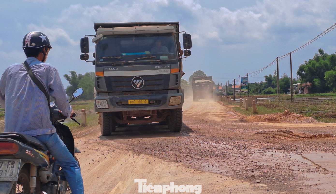 Các xe chở vật liệu thi công cao tốc chạy nối đuôi nhau gây bụi bặm, ảnh hưởng đến người tham gia giao thông. Ảnh: Trương Định