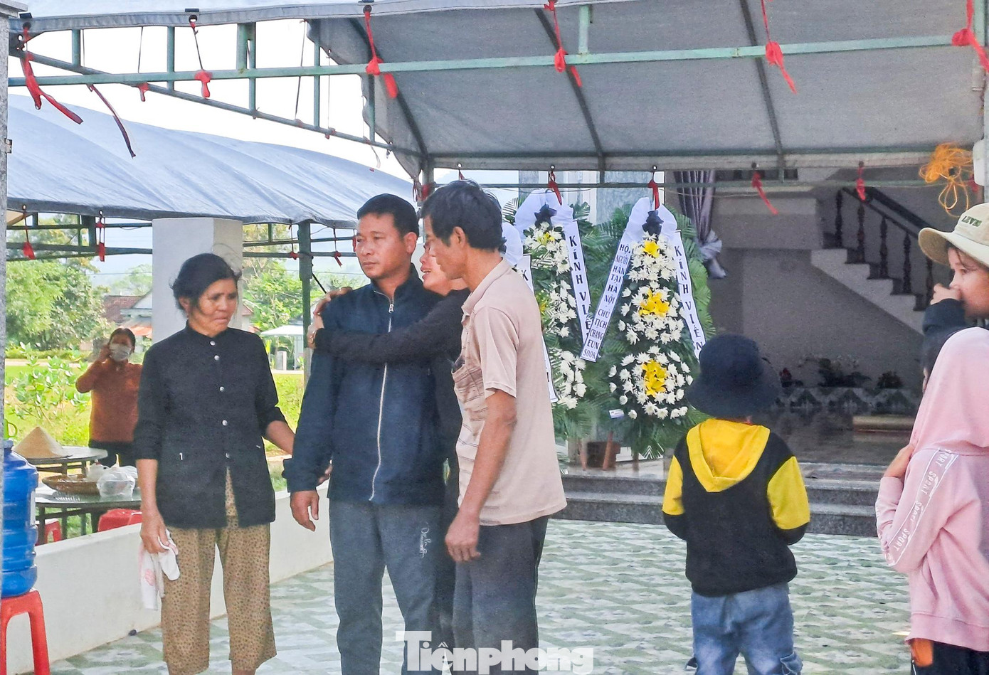 Ông Đinh Khuân (bố của em T., áo khoác đen) đứng đợi xe đưa thi thể con gái. Ảnh: Trương Định Ông Đinh Khuân (bố của em T., áo khoác đen) đứng đợi xe đưa thi thể con gái. Ảnh: Trương Định