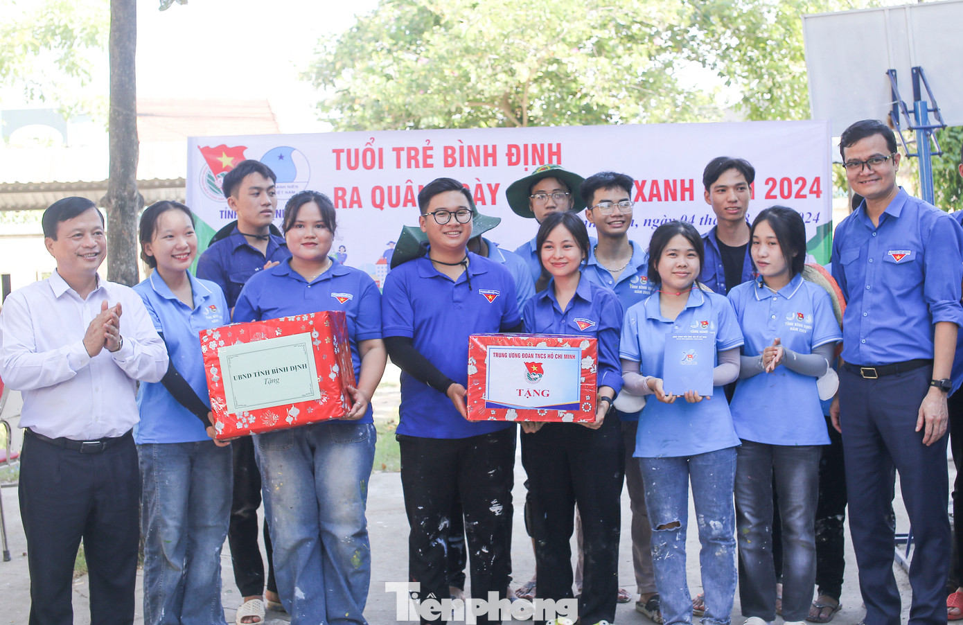 Anh Bùi Quang Huy (bên phải) cùng ông Nguyễn Tuấn Thanh (bên trái) tặng quà cho đội TNTN. Ảnh: Trương Định