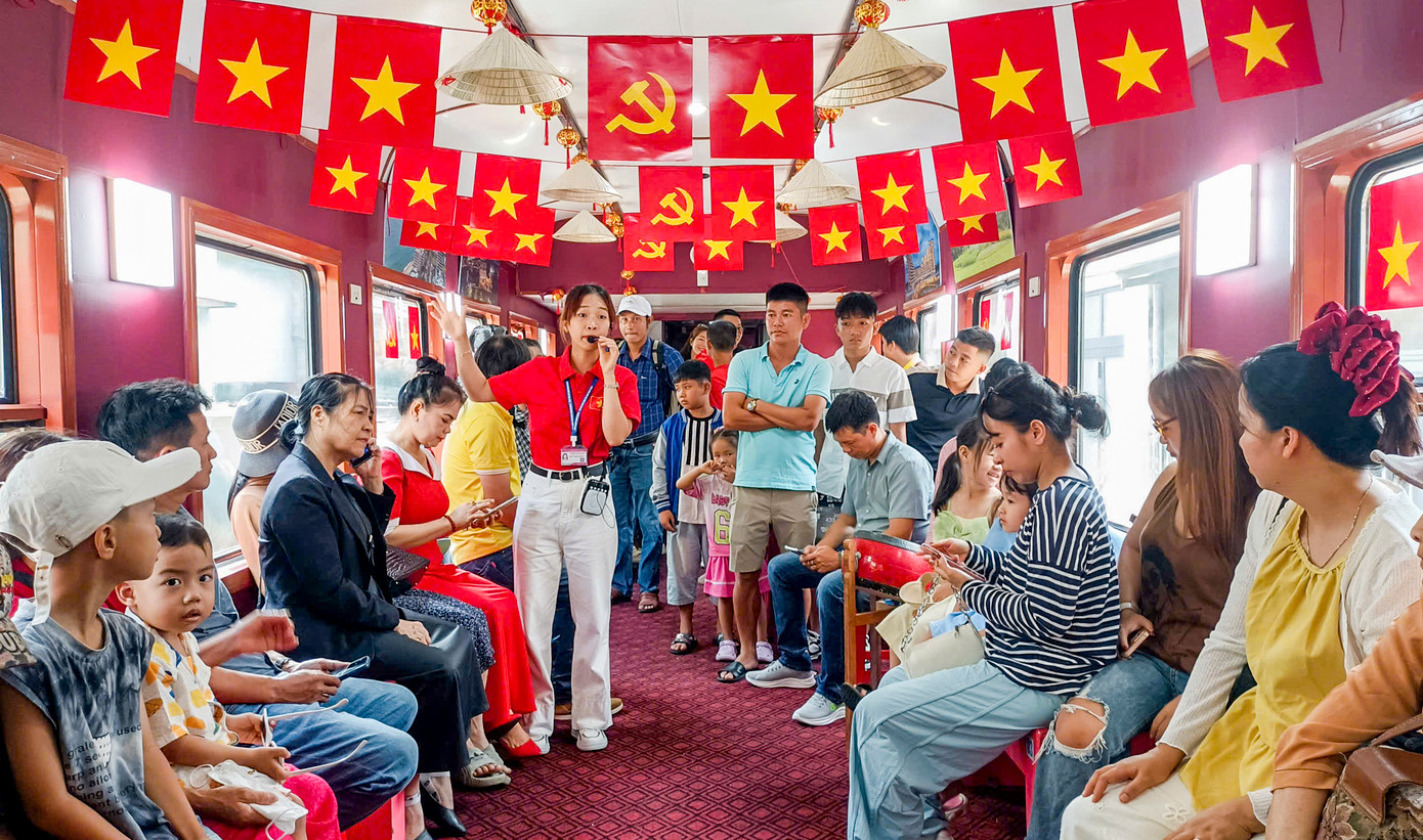 Du khách chăm chú theo dõi hướng dẫn viên giới thiệu.