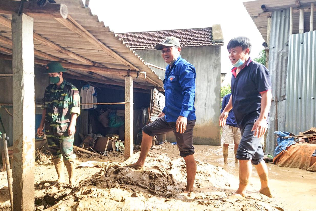 Hỗ trợ người dân vùng bị sạt lở, đất đá tràn vào nhà. Ảnh: Trương Định