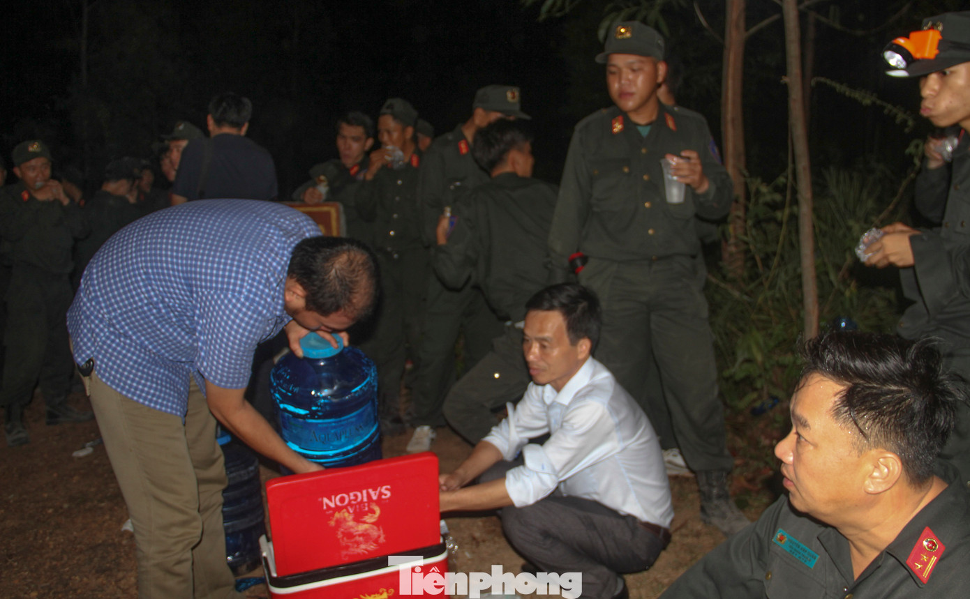 Ông Bùi Tấn Thành - Phó Giám đốc Sở NN&amp;PTNT tỉnh Bình Định (người ngồi áo trắng) lấy nước uống cho các chiến sĩ. Ảnh: Trương Định