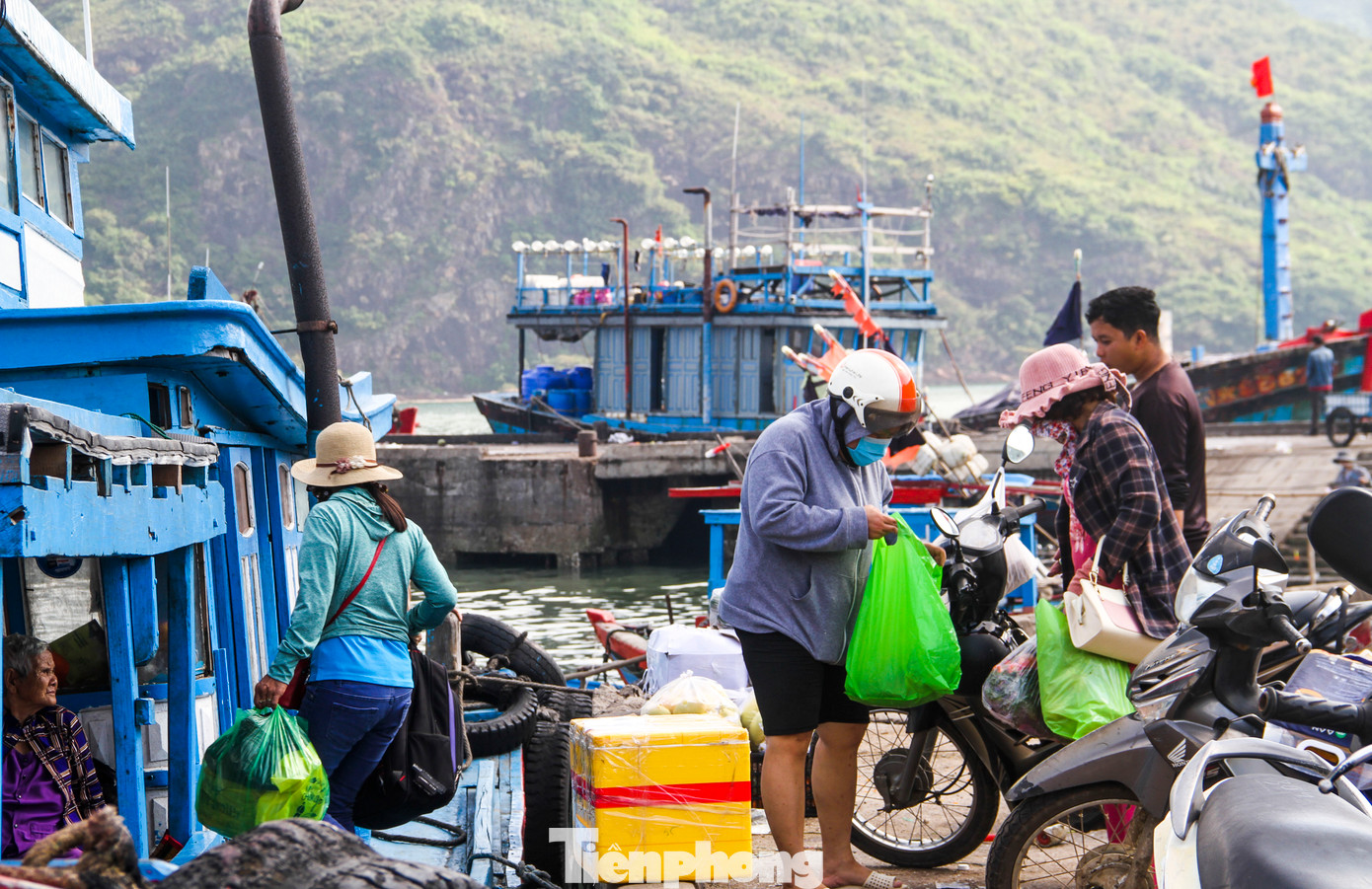 Sáng nay, bà Hồ Thị Hương (81 tuổi, xã Nhơn Châu) theo chuyến đò vào đất liền để thăm con cháu ở Quy Nhơn và tranh thủ mua ít bánh trái về sắm sửa ngày Tết. Bà Hương nói: "Mấy đứa con điện thoại bảo ngày 28 âm lịch hẵng về, rồi mua đồ về gói bánh tét luôn, nhưng hôm nay có việc nên vào sớm". Ảnh: Trương Định