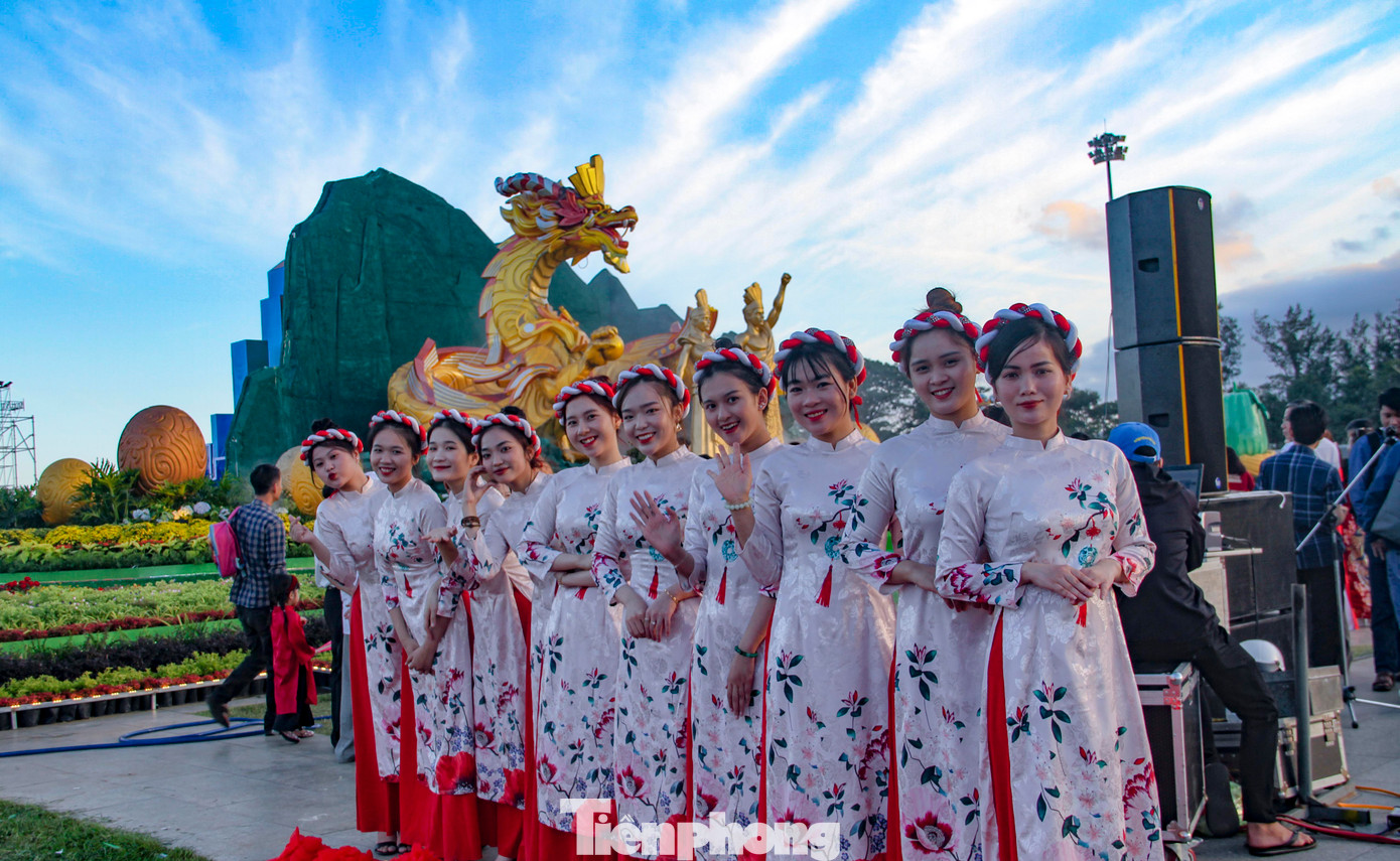 Các bạn trẻ diện áo dài check - in tại biểu tượng linh vật rồng. (Ảnh: Trương Định)