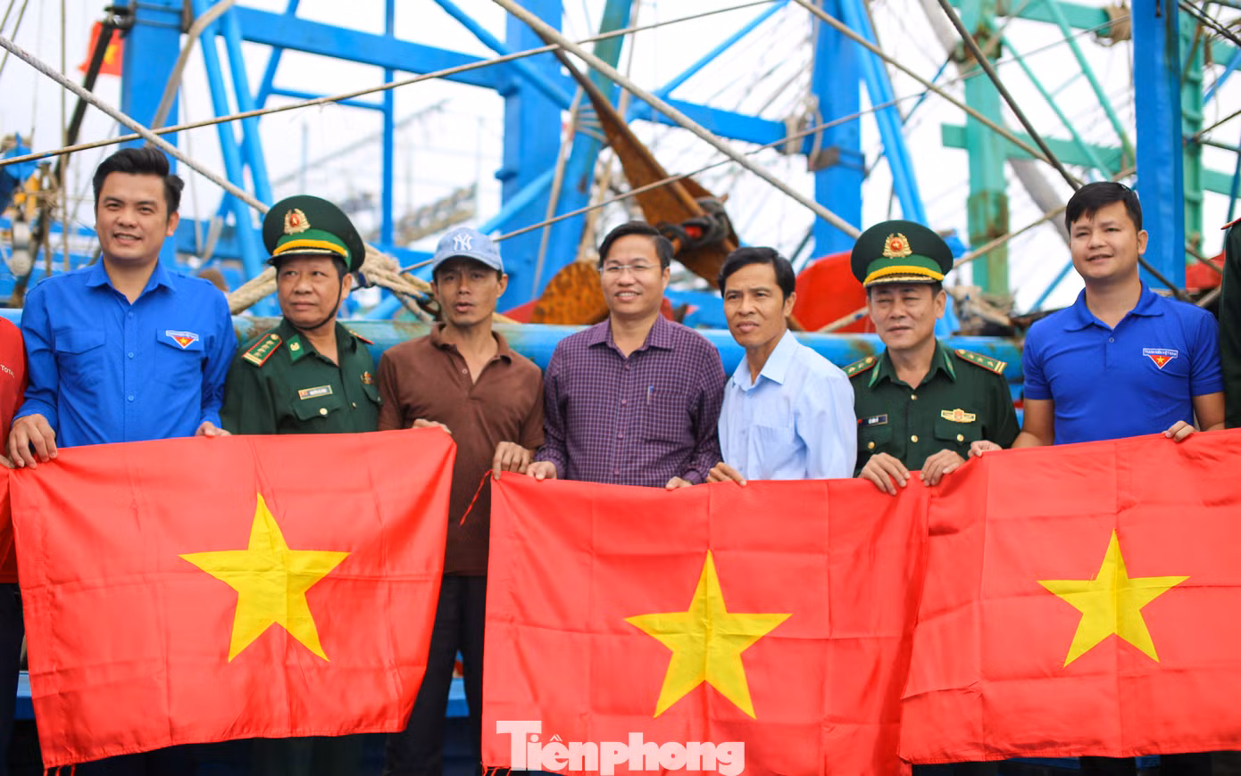 Trao tặng cờ Tổ quốc cho ngư dân. Ảnh: Trương Định