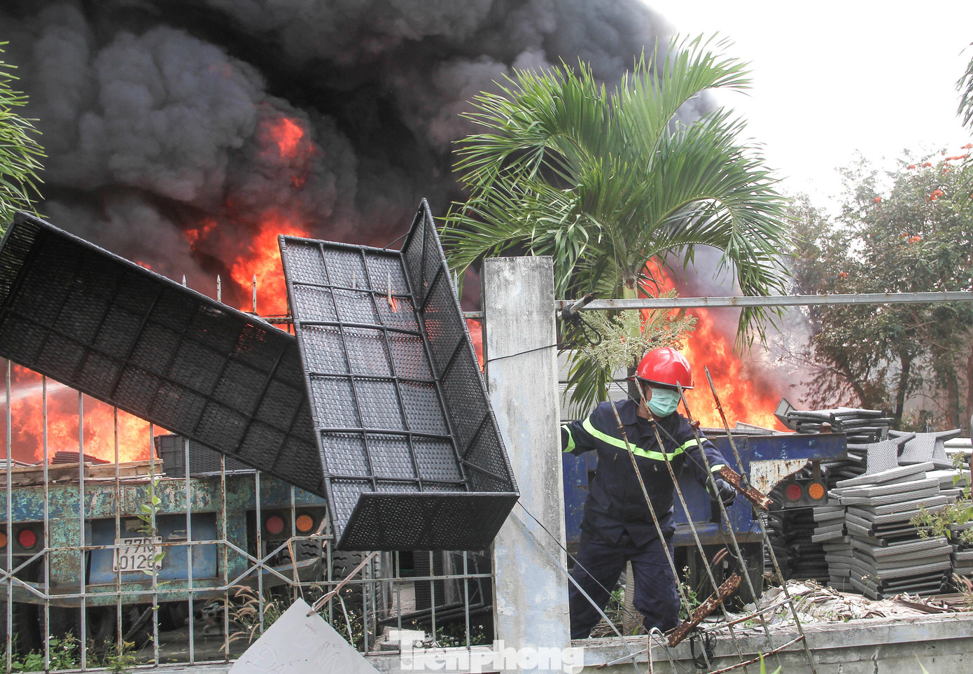 Di dời những tấm mây đan ra khỏi đám cháy, cứu tài sản. Ảnh: Trương Định