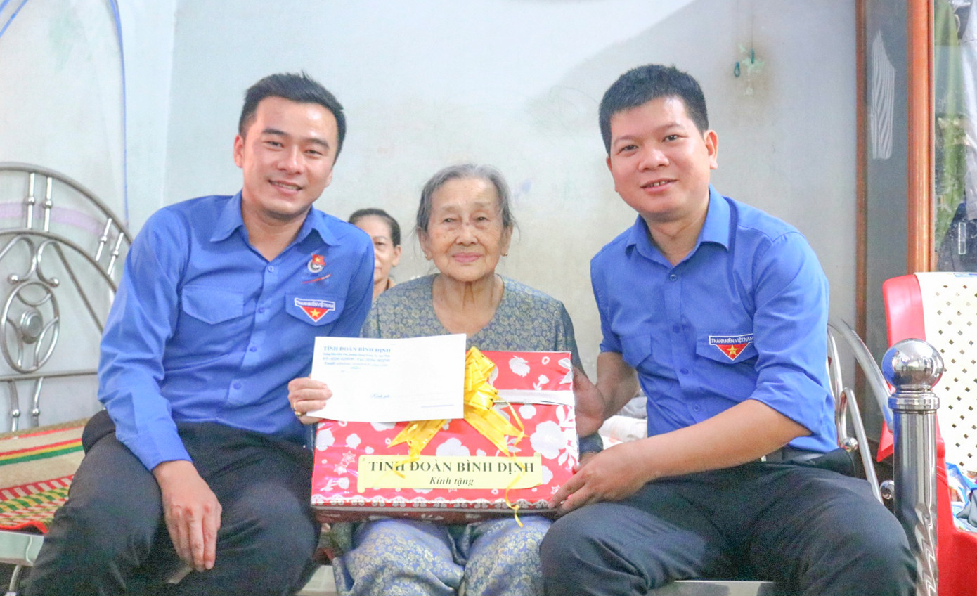 Anh Lý Anh Việt - Phó Bí thư Tỉnh Đoàn Bình Định trao quà cho Mẹ Việt Nam Anh hùng Từ Thị Nghiệm. Ảnh: T.Đ