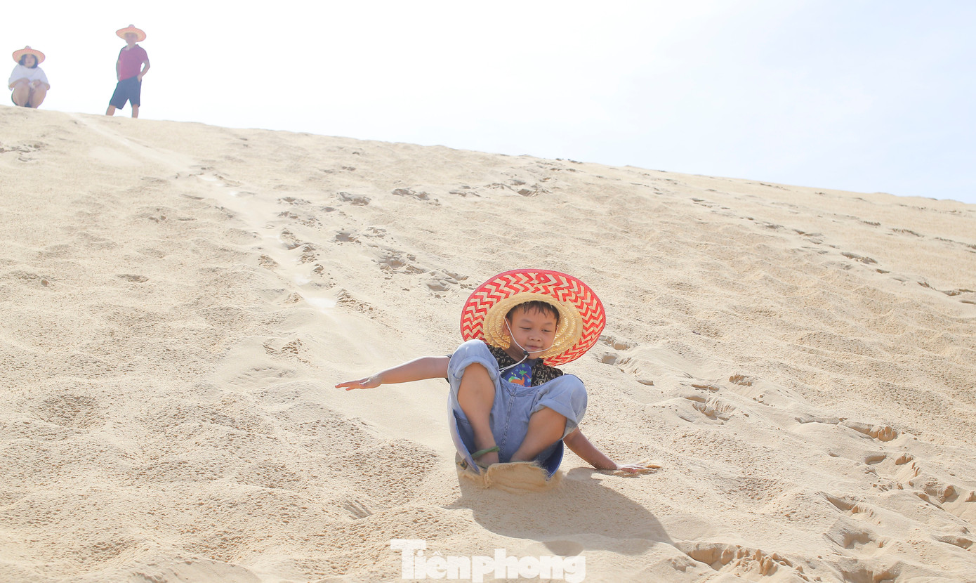 Các em nhỏ thích thú chơi trượt cát. Ảnh: Trương Định. Các em nhỏ thích thú chơi trượt cát. Ảnh: Trương Định.