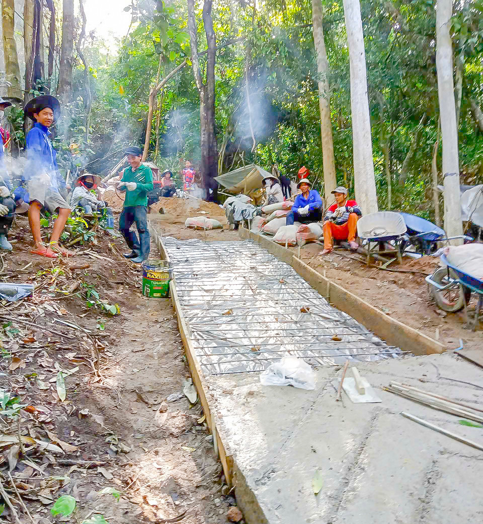 Dưới cái nắng gắt, những đoạn đường bê tông đầu tiên đã được hoàn thành, dài khoảng 700 - 800m. Mỗi mét đường xây nên không chỉ bằng xi măng, sỏi cát, mà còn bằng mồ hôi, bằng quyết tâm và niềm tin vào một ngày mai tươi sáng hơn.