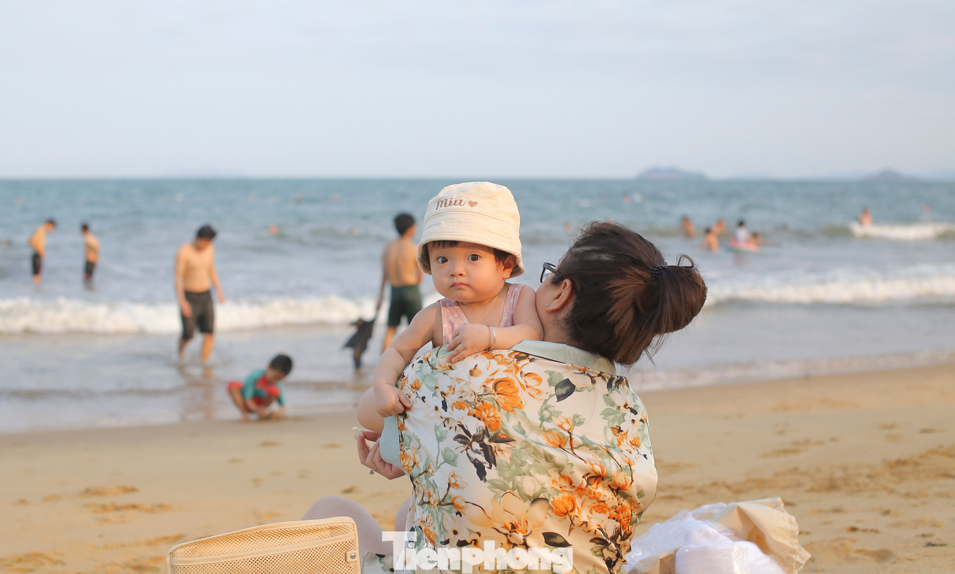 Một số gia đình dẫn theo các em nhỏ ra biển dạo chơi, hóng mát. Ảnh: Trương Định