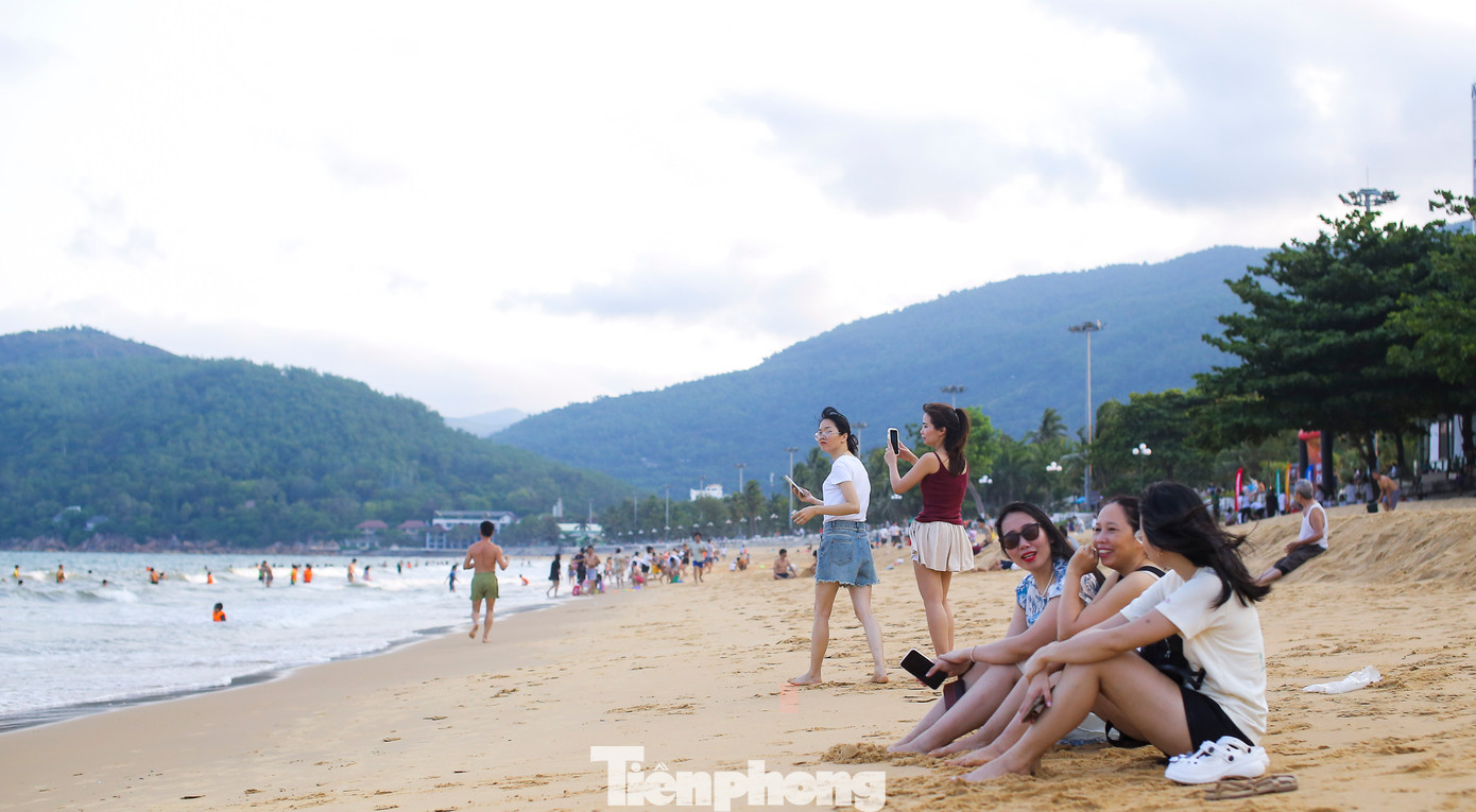 Thời tiết nắng nóng, nhiều du khách và người dân địa phương bắt đầu đổ về biển Quy Nhơn để tắm giải nhiệt từ rất sớm. Theo ghi nhận của Tiền Phong, khu vực biển dọc các tuyến đường An Dương Vương và Xuân Diệu (thành phố Quy Nhơn) càng về chiều tối lượng người đổ về mỗi lúc một đông hơn. Ảnh: Trương Định