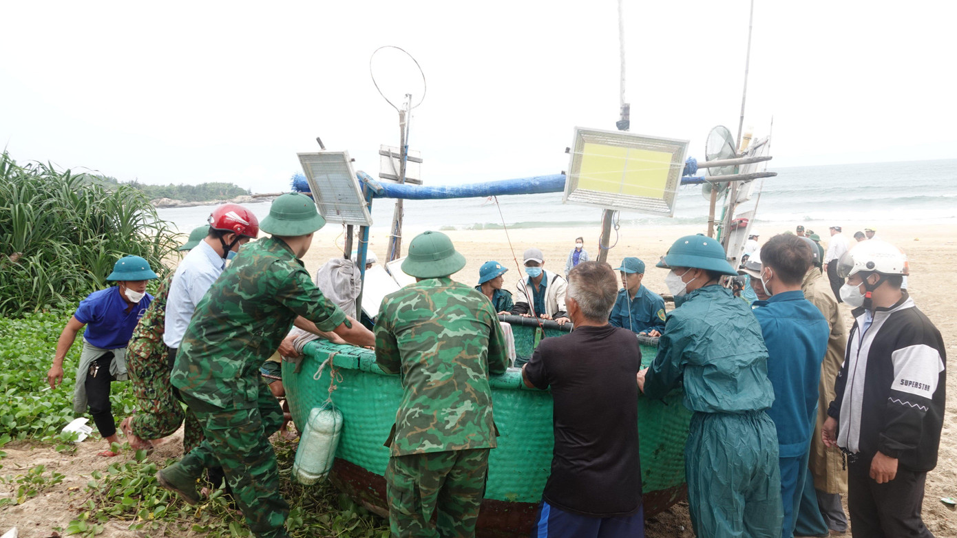 Các lực lượng hỗ trợ đưa thuyền thúng của ngư dân vào bờ.