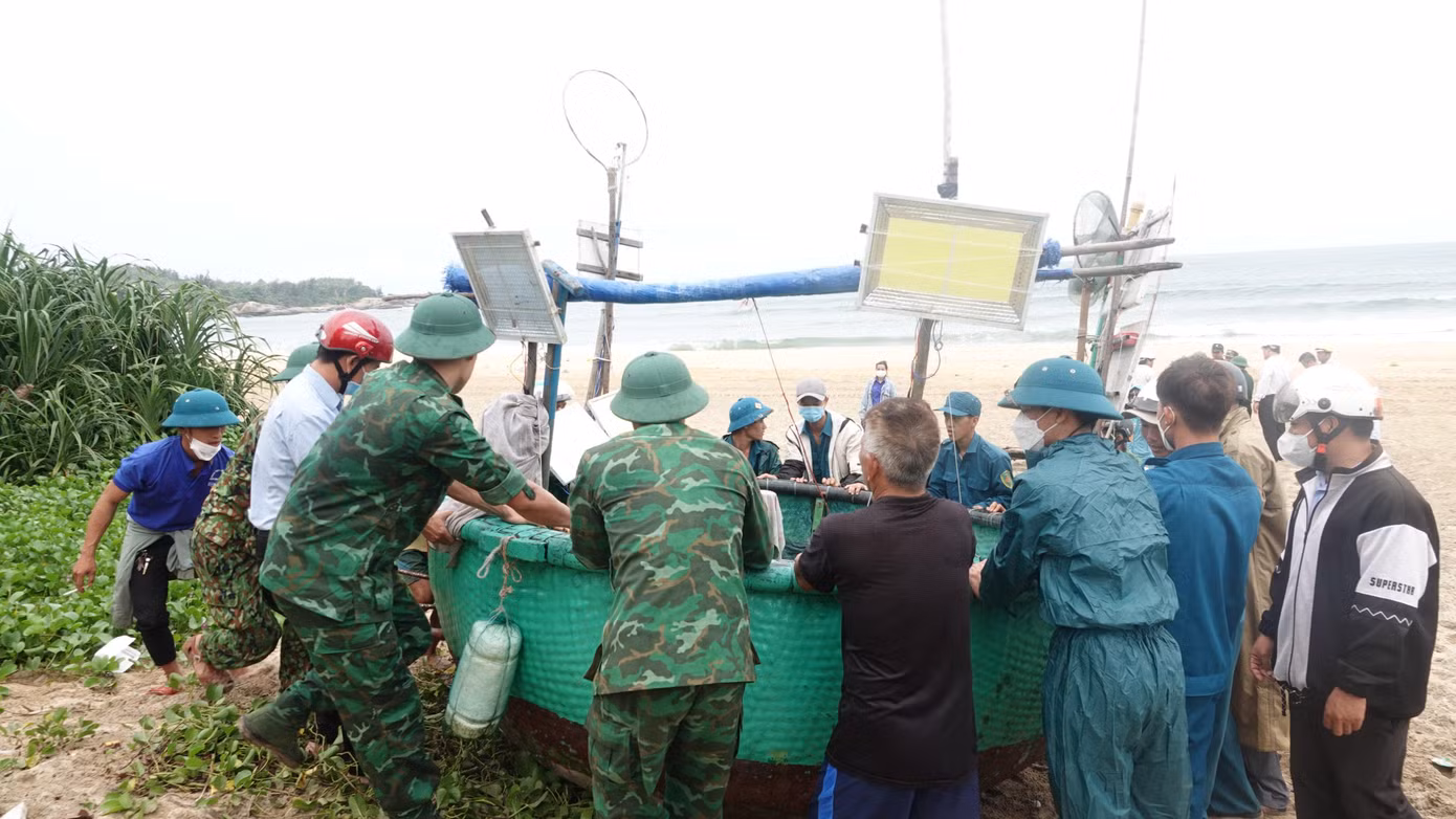 Các lực lượng hỗ trợ đưa thuyền thúng của ngư dân vào bờ.