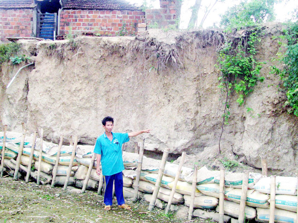 Thủy điện xả nước khiến đất lở đến tận vách nhà dân. Ảnh: V.H