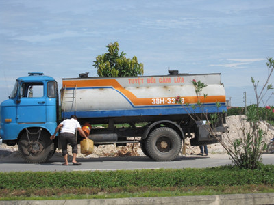 Một lái xe đang rút xăng để bán . Ảnh: M.T Một lái xe đang rút xăng để bán
