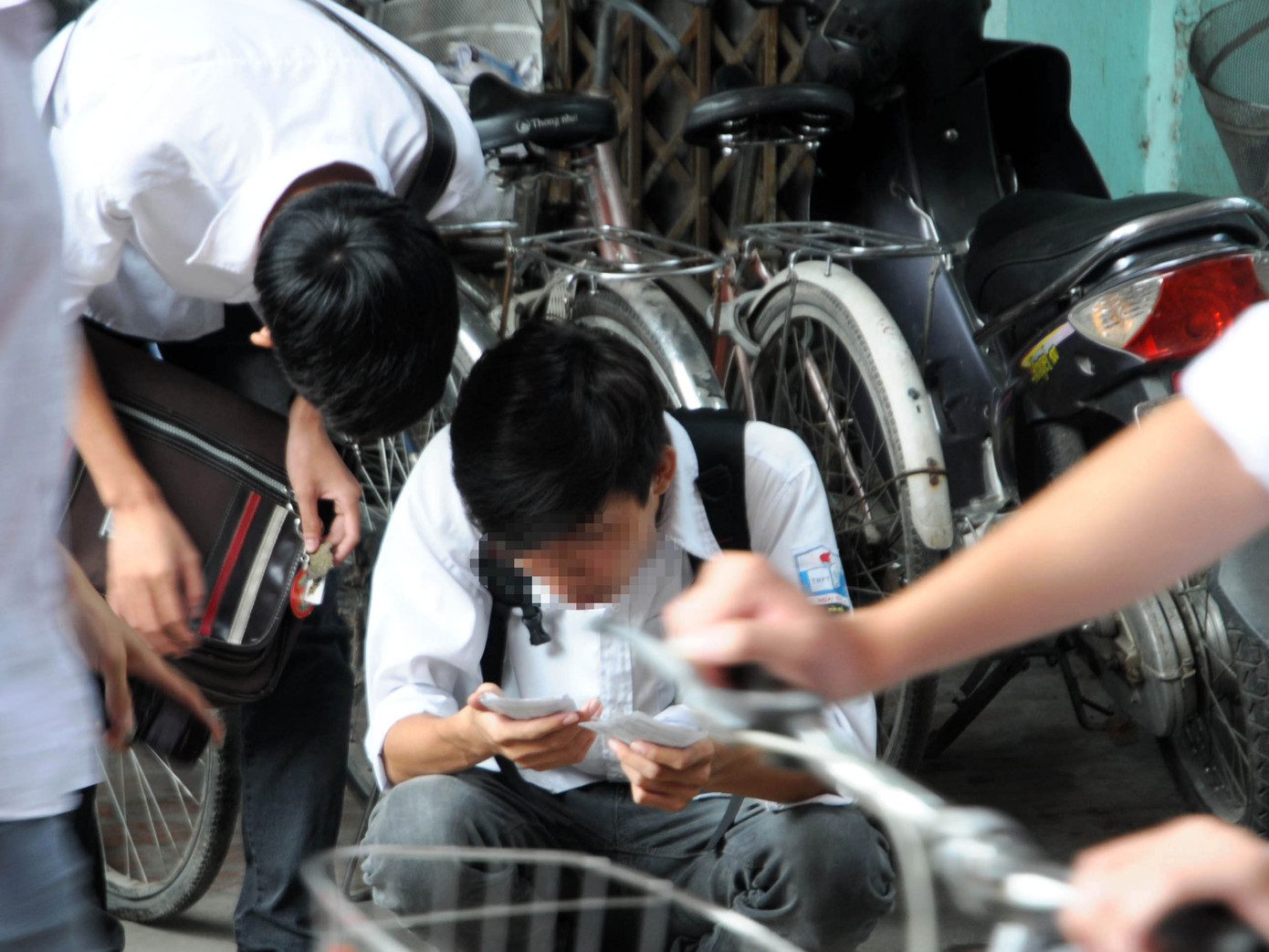 Hai thí sinh hồn nhiên mở phao thi xem lại kết quả trước trường THPT Hoài Đức A