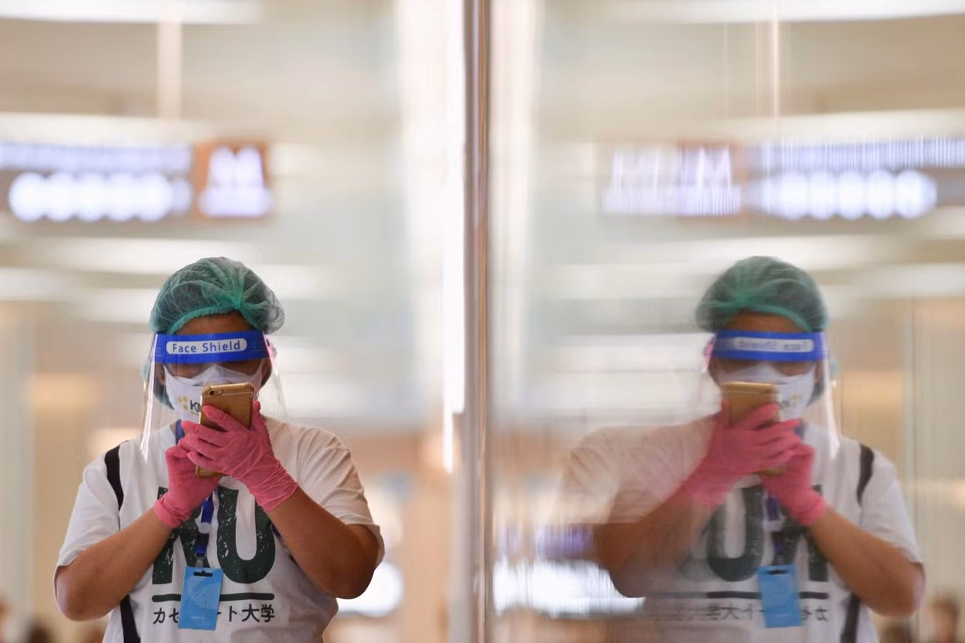 Một phụ nữ đeo đầy đủ phụ kiện bảo hộ khi đến trung tâm thương mại. Ảnh: Reuters