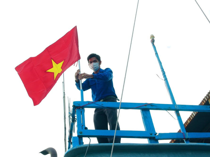 Thanh niên Khánh Hoà gắn cờ Tổ quốc lên tàu cá ngư dân