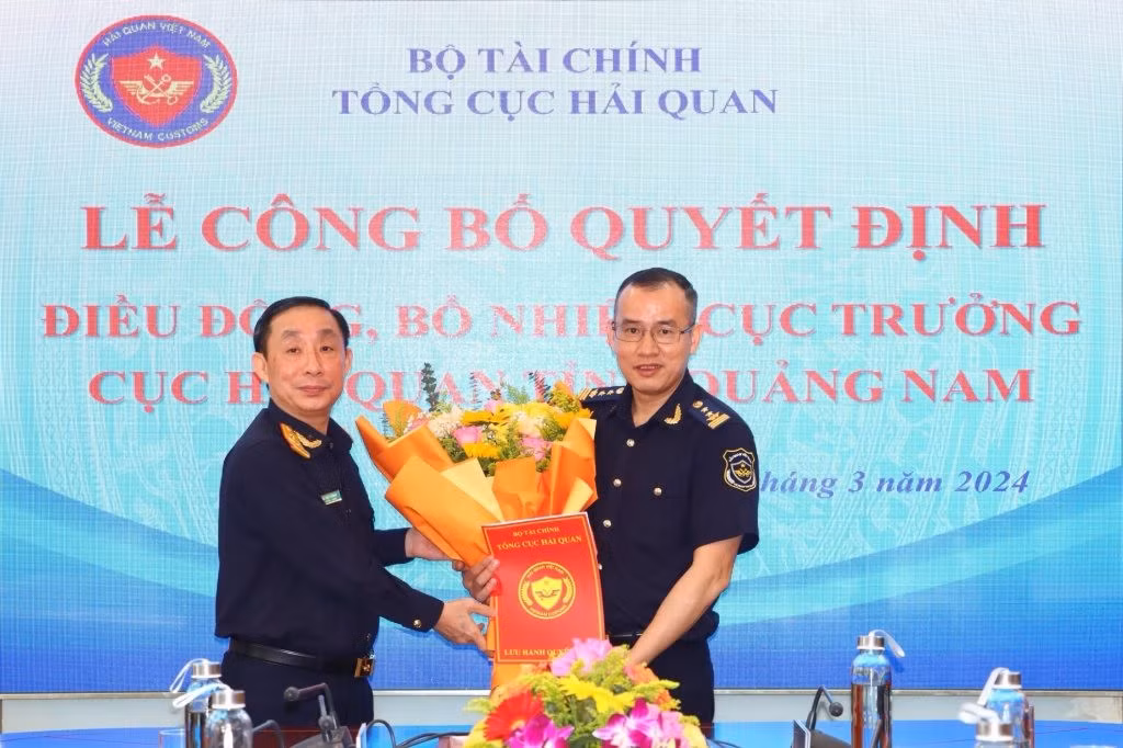 Lãnh đạo Tổng cục Hải quan trao quyết định và tặng hoa chúc mừng ông Dương Xuân Sinh - tân Cục trưởng Cục Hải quan tỉnh Quảng Nam (bên phải). Ảnh: Haiquanonline.com.vn