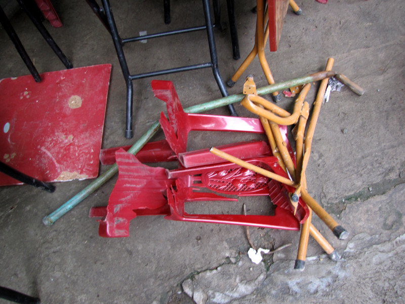 Một chiếc ghế nhựa của quán nước trên vỉa hè cũng bị vỡ vụn