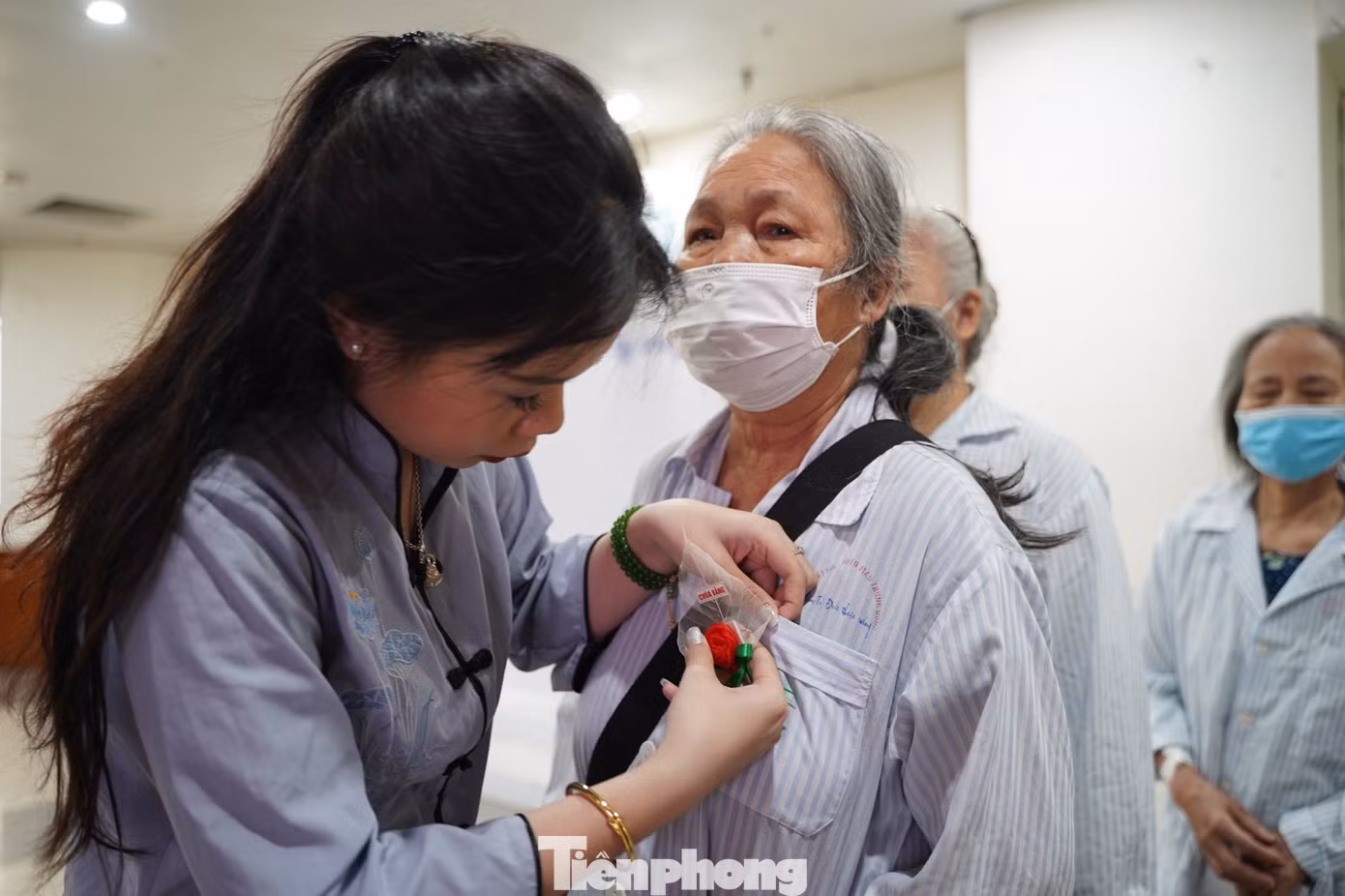 Bệnh nhân và người nhà cài hoa hồng Vu Lan lên ngực áo trước khi dự lễ.
