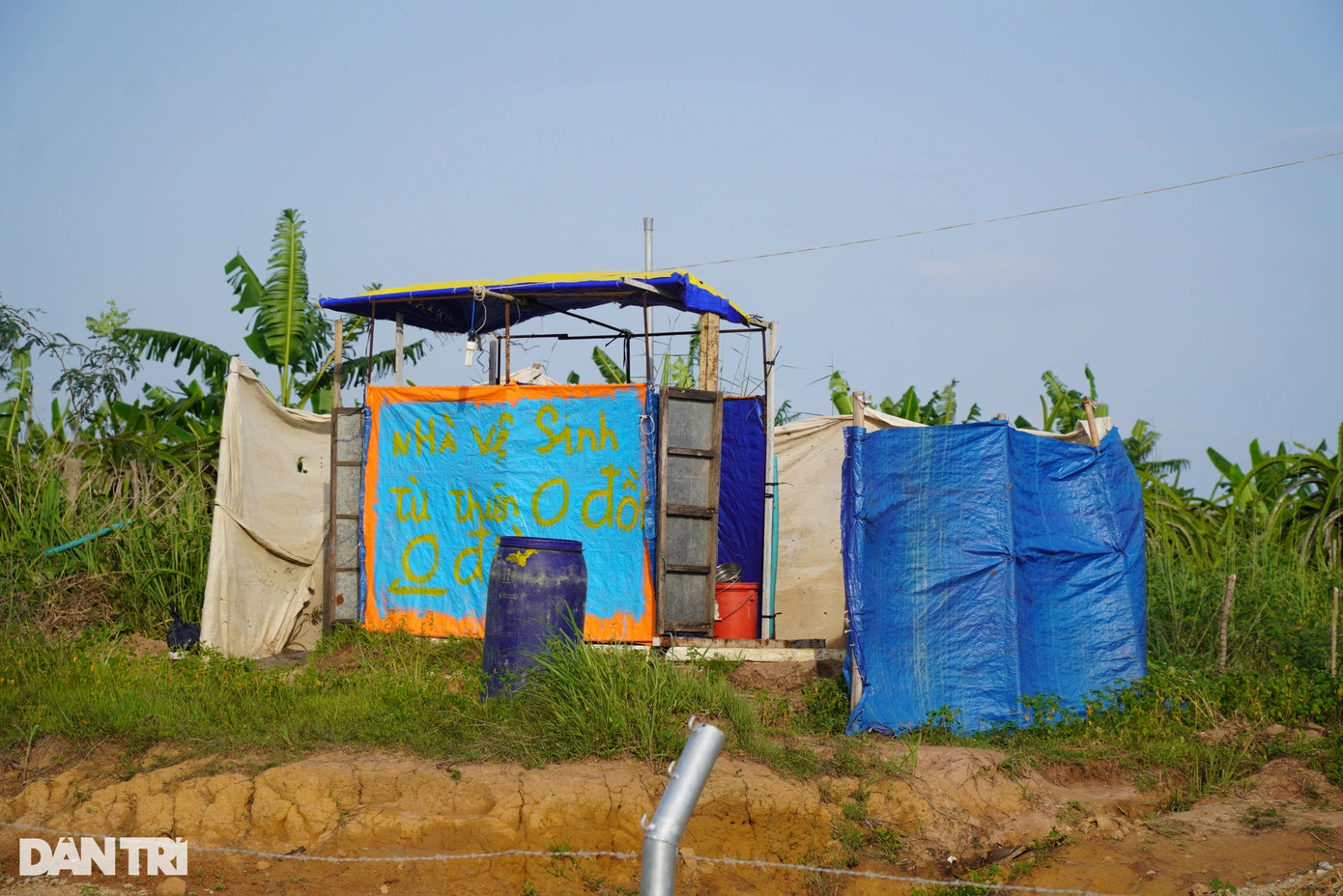 Bên kia hàng rào bảo vệ là một căn chòi dựng tạm khá kín đáo trên rẫy trồng thanh long, cũng có dòng chữ "nhà vệ sinh 0 đồng". Buổi tối, nhà vệ sinh được chủ nhà bắt đèn để bà con đi lại thuận tiện.