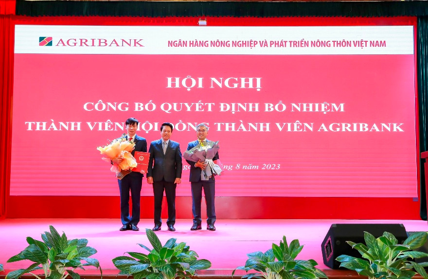 Đ/c Phạm Tiến Dũng – Phó Thống đốc NHNN trao Quyết định và tặng hoa đ/c Phạm Đức Tuấn (bên trái) và đ/c Phan Đình Điền (bên phải)